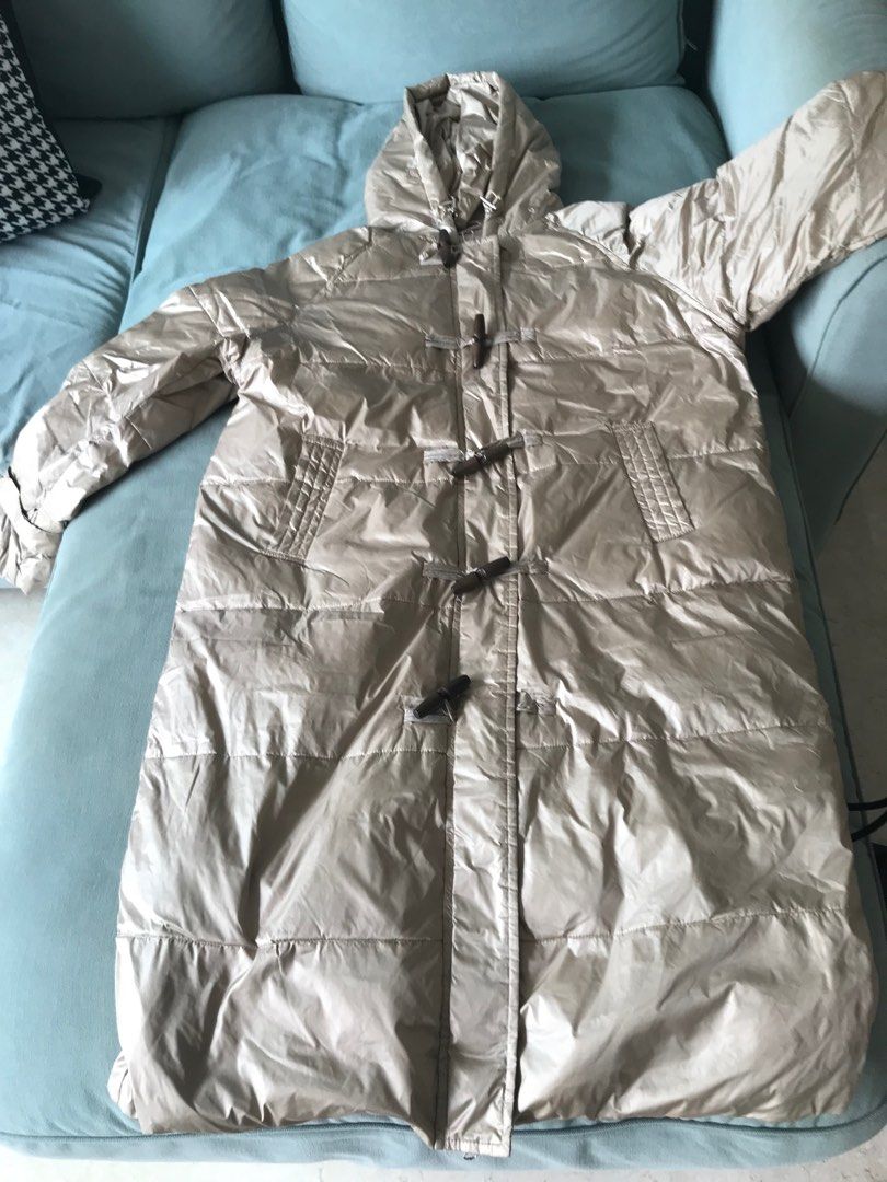 Down jacket (Category: Coats, Jackets and Outerwear) located in Singapore. Submitted by mtyzxhc_802 (Listing ID 1415456313, Image 1). Description: - Longline puffer jacket - Beige color - Features a hood and toggle closures - Lightly used, no visible wear - Versatile for various outfits - Perfect for staying warm and stylish.