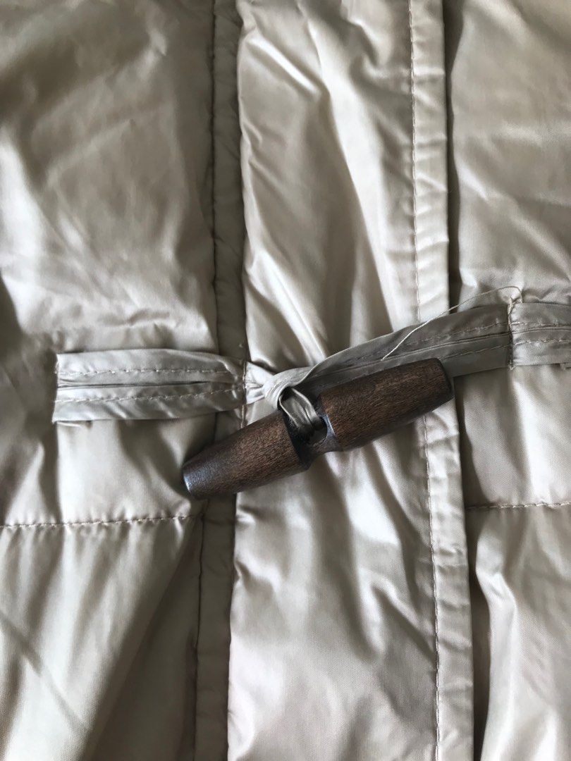 Down jacket (Category: Coats, Jackets and Outerwear) located in Singapore. Submitted by mtyzxhc_802 (Listing ID 1415456313, Image 2). Description: - Longline puffer jacket - Beige color - Features a hood and toggle closures - Lightly used, no visible wear - Versatile for various outfits - Perfect for staying warm and stylish.