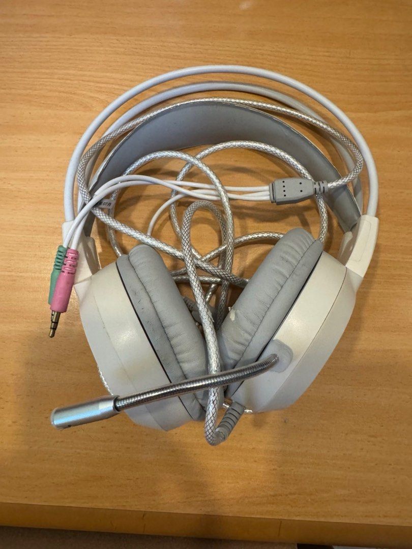Gaming Headset with Microphone (Category: Headphones & Headsets) located in Quezon City. Submitted by things.matter (Listing ID 1415448985, Image 1). Description: Gaming headset with a built-in microphone. It has a white and gray color scheme. The headset has a USB connector and two 3.5mm audio jacks. The earcups are padded for comfort. The microphone is flexible and can be adjusted..