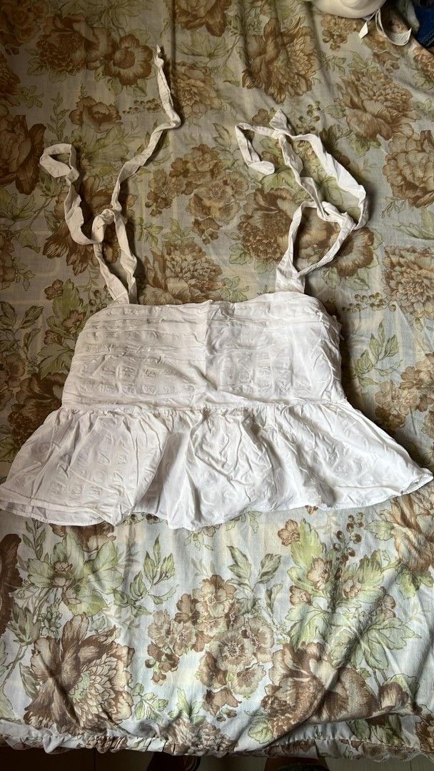 H&M White Ruffled Top (Category: Blouses) located in Manila. Submitted by nicoleanne84656 (Listing ID 1415465843, Image 1). Description: - White tie-strap top - Ruffled hem - Fitted bodice - Flared, layered skirt - Lightweight fabric - Adjustable tie straps - Perfect for warm weather - Simple and elegant design.