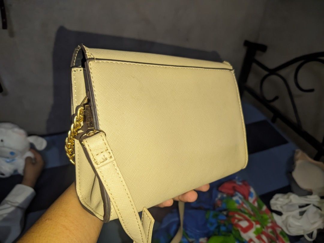 Kate Spade Shoulder Bag (Category: Luxury Bags & Wallets) located in Tarlac. Submitted by yellowieewo (Listing ID 1415584182, Image 2). Description: PRICE NEGOTIABLE - Cream-colored Kate Spade shoulder bag - Elegant gold chain detail - Secure flap closure with magnetic snap - Interior lined with fabric - Shoulder strap with some wear - Classic rectangular shape.