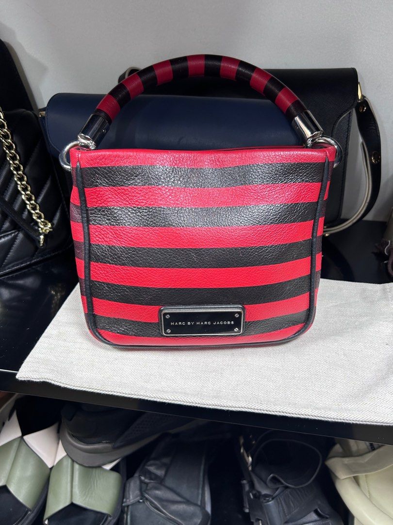 Marc by Marc Jacobs Striped Handbag (Category: Luxury Bags & Wallets) located in Pateros City. Submitted by blitzkriegspc (Listing ID 1415493275, Image 1). Description: - Marc by Marc Jacobs handbag - Striking red and black striped design - Top handle with matching stripes - Black interior with zippered pocket - Rectangular shape - Silver-toned hardware - Brand name visible on front and inside.