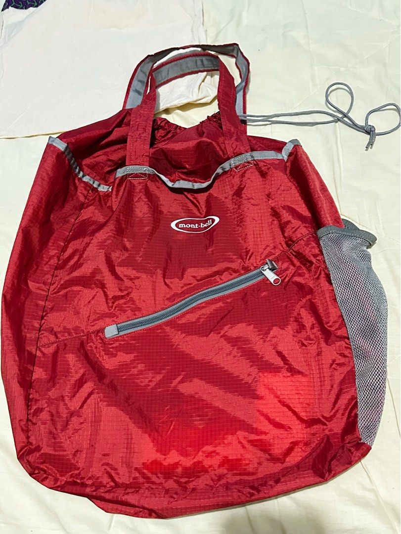 Mont-Bell Tote bag Pocketable Light (Category: Backpacks) located in General Santos City (Dadiangas). Submitted by toysville888 (Listing ID 1415490003, Image 1). Description: This is a red Mont-bell packable tote bag made from water-resistant nylon material. It features: An ultra-lightweight design that folds into a compact size. A spacious main compartment with drawstring closure. mesh side pocket for water bottles or other items. A front zipper