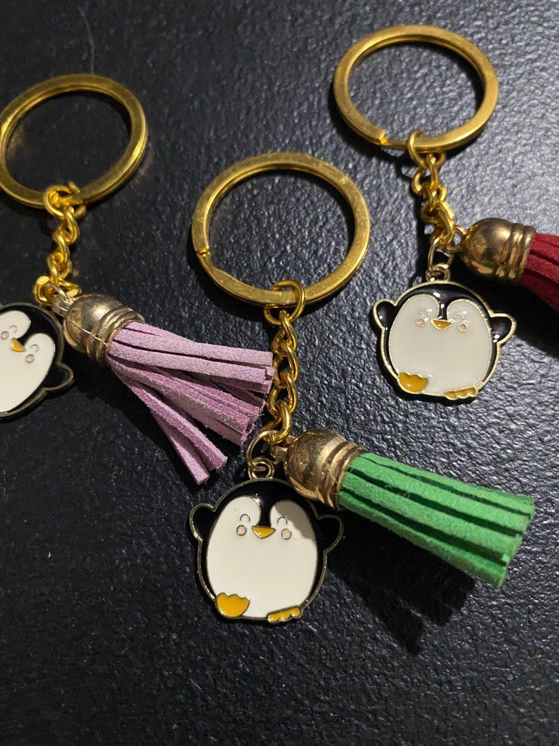 Penguin Keychains with Tassels (Category: Character Goods) located in Valenzuela. Submitted by emg.everythingmustgo (Listing ID 1415554877, Image 3). Description: 100 each Adorable penguin keychains with colorful tassels. Each keychain features a cute penguin charm with a gold-colored chain and keyring. The tassels come in various colors, including red, green, pink, orange, blue, and purple. Perfect for adding a touch of fun to your keys or bags.
