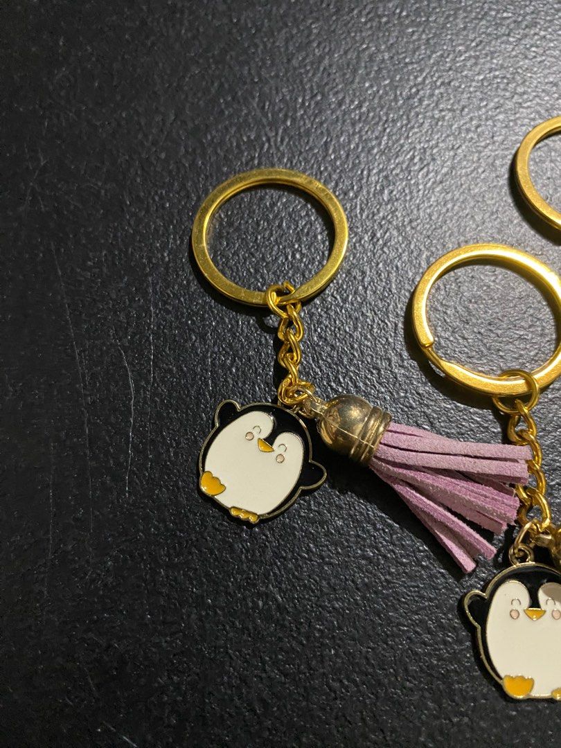 Penguin Keychains with Tassels (Category: Character Goods) located in Valenzuela. Submitted by emg.everythingmustgo (Listing ID 1415554877, Image 2). Description: 100 each Adorable penguin keychains with colorful tassels. Each keychain features a cute penguin charm with a gold-colored chain and keyring. The tassels come in various colors, including red, green, pink, orange, blue, and purple. Perfect for adding a touch of fun to your keys or bags.