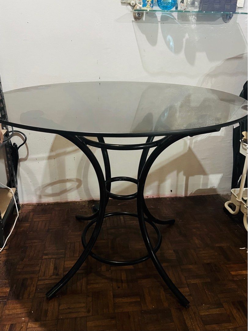 Round Glass Top Table (Category: Tables & Sets) located in Rizal. Submitted by gonzalesliza58 (Listing ID 1415510011, Image 1). Description: - Round table - Black metal frame - Tinted glass top - Central support ring, three legs - Shows some wear on glass top - Perfect for small dining or side table.