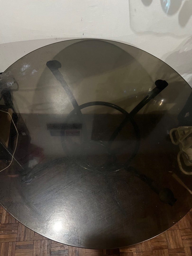 Round Glass Top Table (Category: Tables & Sets) located in Rizal. Submitted by gonzalesliza58 (Listing ID 1415510011, Image 2). Description: - Round table - Black metal frame - Tinted glass top - Central support ring, three legs - Shows some wear on glass top - Perfect for small dining or side table.