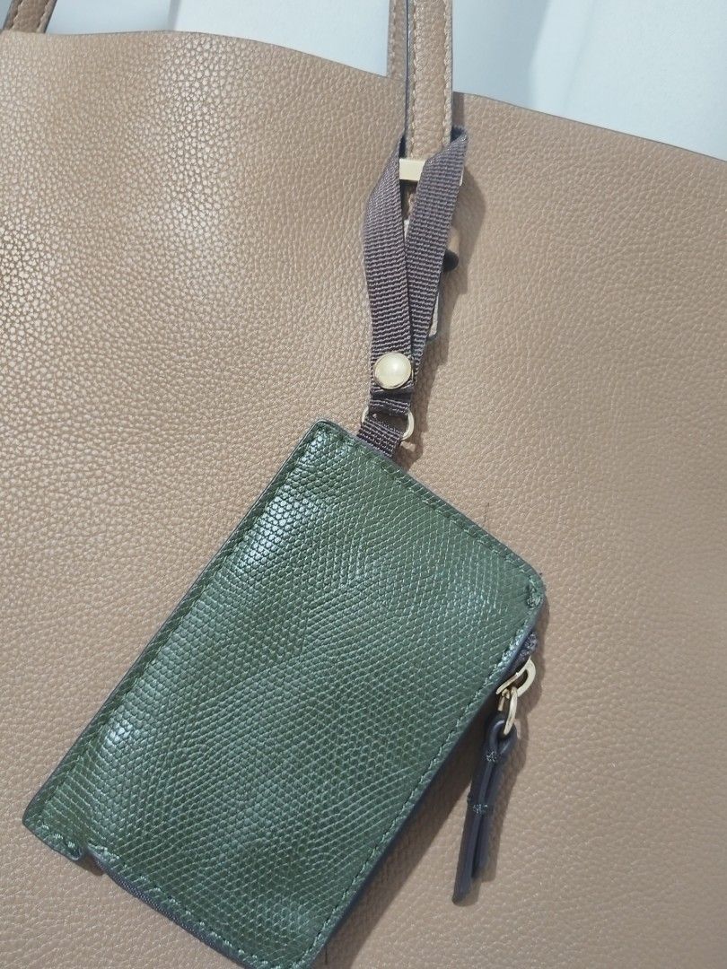 Tan Tote Bag with Detachable Pouch (Category: Tote Bags) located in Manila. Submitted by t.reyes (Listing ID 1415571916, Image 3). Description: - Tan tote bag - Includes a detachable green pouch - Features two shoulder straps - Gold-colored hardware - Made of smooth, leather-like material - Interior zippered pocket for security - Spacious interior.