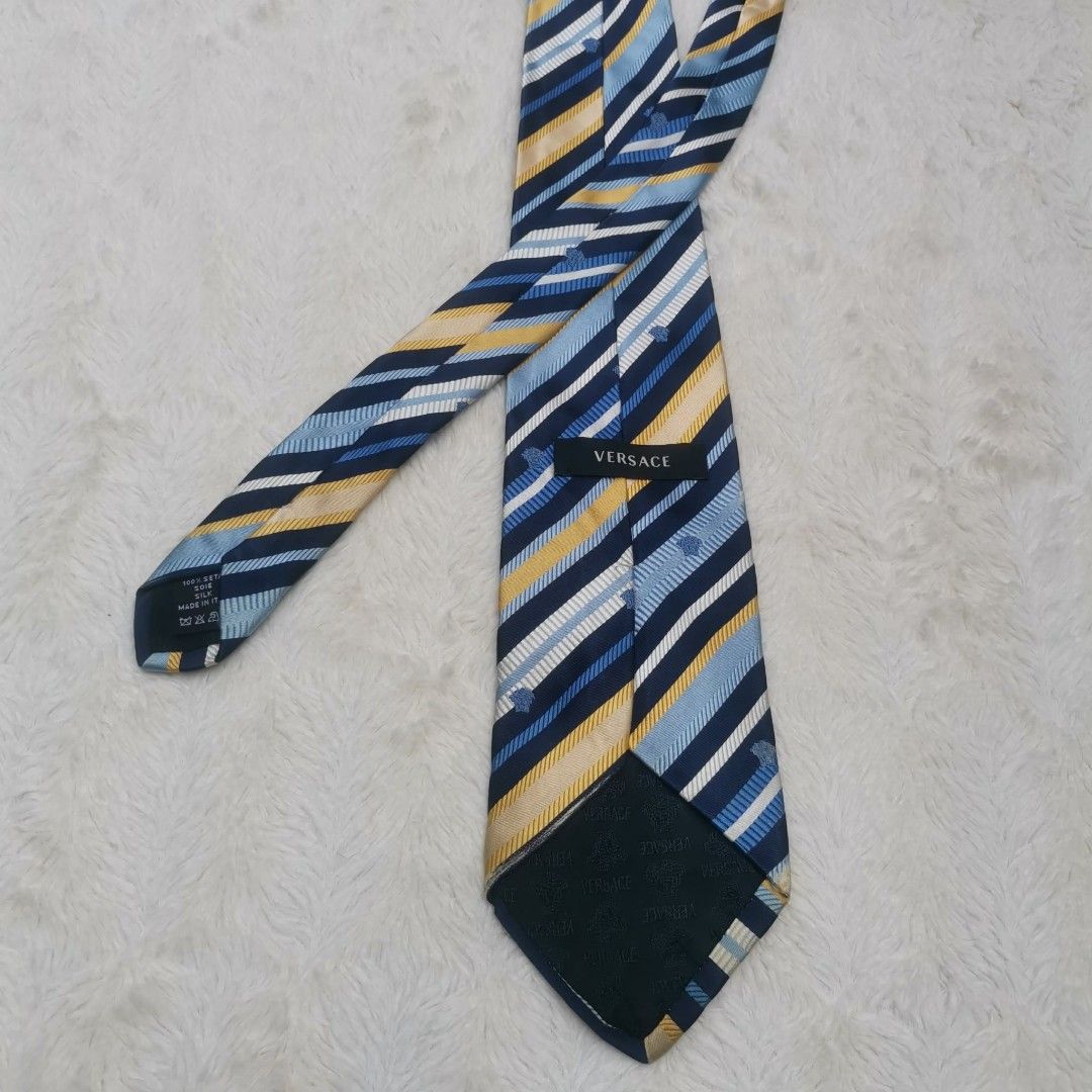 Versace Striped Silk Tie (Category: Ties) located in Manila. Submitted by titojay (Listing ID 1415456281, Image 1). Description: Authentic Versace tie featuring a striped pattern in navy, yellow, and light blue. The tie has the Versace logo on the label. The tie has a classic design, suitable for formal or semi-formal occasions..