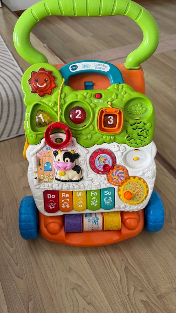 VTech Learning Walker (Category: Infant Playtime) located in Kuala Lumpur. Submitted by mhanifz (Listing ID 1415487379, Image 1). Description: - VTech Learning Walker - Detachable activity panel with numbers, shapes, and musical notes - Features interactive elements like a cow, gears, and piano keyboard - Designed to help babies learn and develop motor skills - Easy-to-push handle.