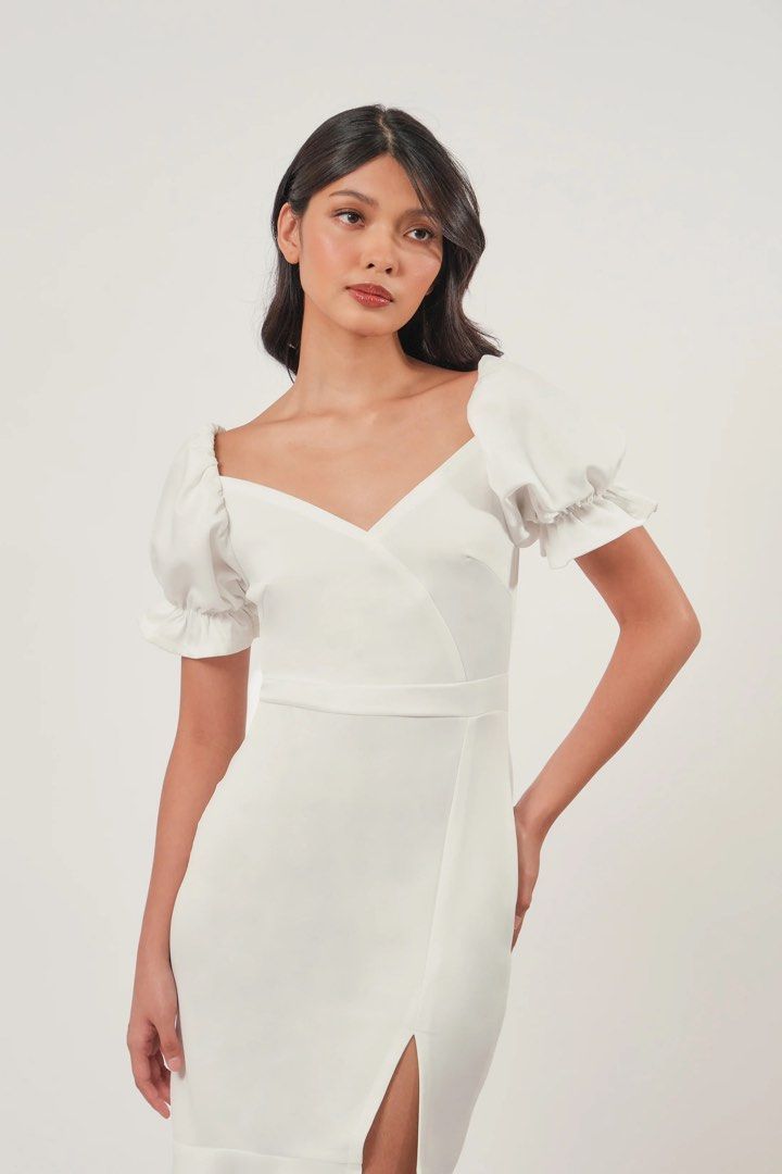 White Midi Dress with Puff Sleeves (Category: Dresses) located in Quezon City. Submitted by rossyl_22 (Listing ID 1415594778, Image 2). Description: - White midi dress - Sweetheart neckline - Short puff sleeves - Fitted bodice - Defined waist - Mermaid hem with front slit - Smooth, likely stretchy fabric - Ideal for special occasions.