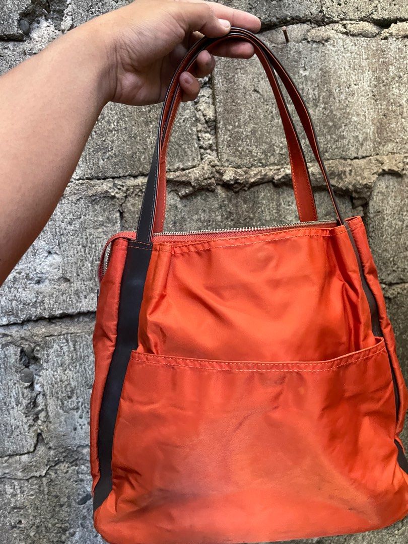 Y's Sacs Orange Tote Bag (Category: Tote Bags) located in Alfonso. Submitted by assortedg3 (Listing ID 1415594707, Image 3). Description: - Y's Sacs orange tote bag - Zip closure - Brown leather accents - Interior pocket - Rectangular shape - Two shoulder straps - Brown fabric lining - Includes interior tag.