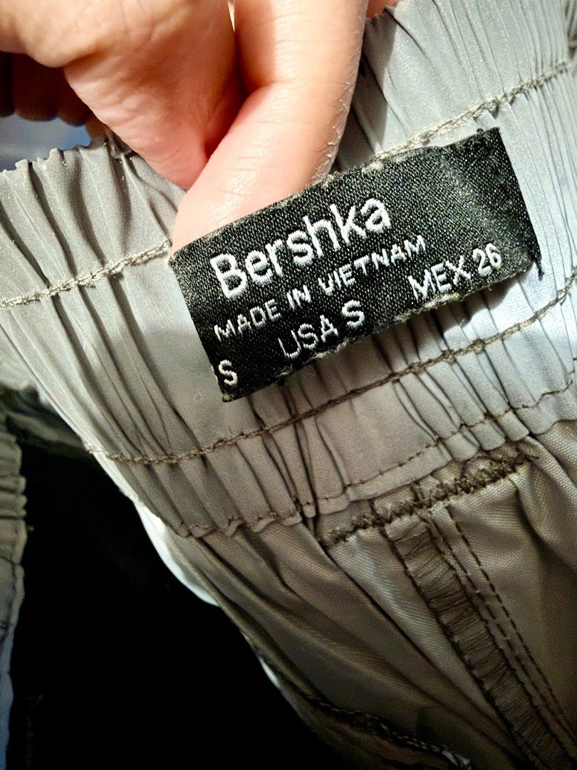 Bershka Cargo Pants - Size S (Category: Jeans) located in Pasig City. Submitted by prioritylaine (Listing ID 1415678935, Image 3). Description: Bershka cargo pants in size S. Features a light grey color with black mesh detailing on the sides. Includes two cargo pockets on the front and a zippered pocket at the back. The pants have an elastic waistband and cuffs. Made in Vietnam. With slight dirt, washable.