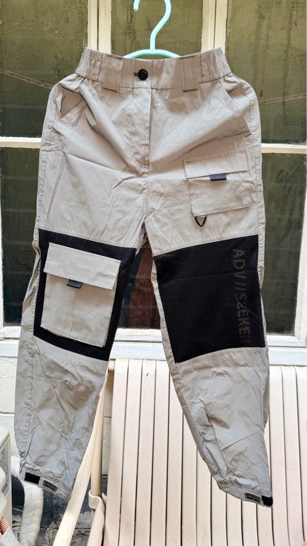 Bershka Cargo Pants - Size S (Category: Jeans) located in Pasig City. Submitted by prioritylaine (Listing ID 1415678935, Image 1). Description: Bershka cargo pants in size S. Features a light grey color with black mesh detailing on the sides. Includes two cargo pockets on the front and a zippered pocket at the back. The pants have an elastic waistband and cuffs. Made in Vietnam. With slight dirt, washable.