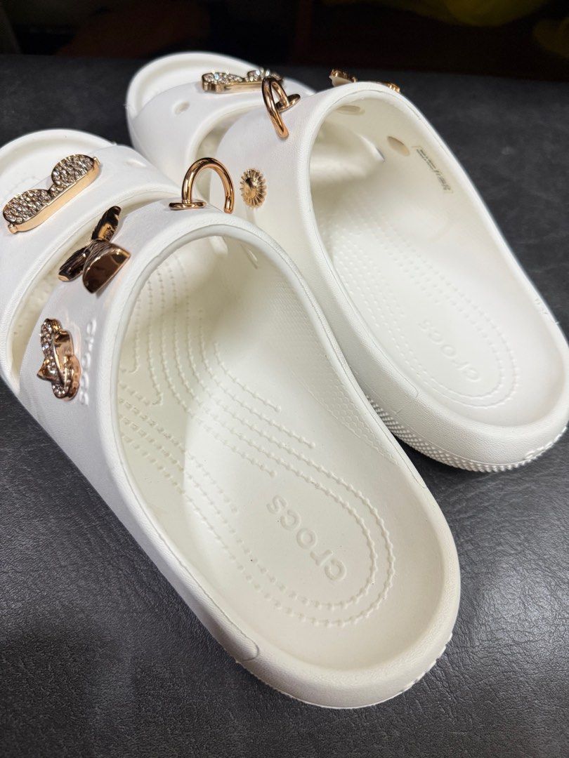 Crocs Sandals with Jibbitz Charms (Category: Flats & Sandals) located in Manila. Submitted by thegreat21 (Listing ID 1415727040, Image 3). Description: White Crocs sandals with Jibbitz charms. Features gold-colored charms. Double-strap design. Size W8/M6. Good as new, once used not my style of double strap. .