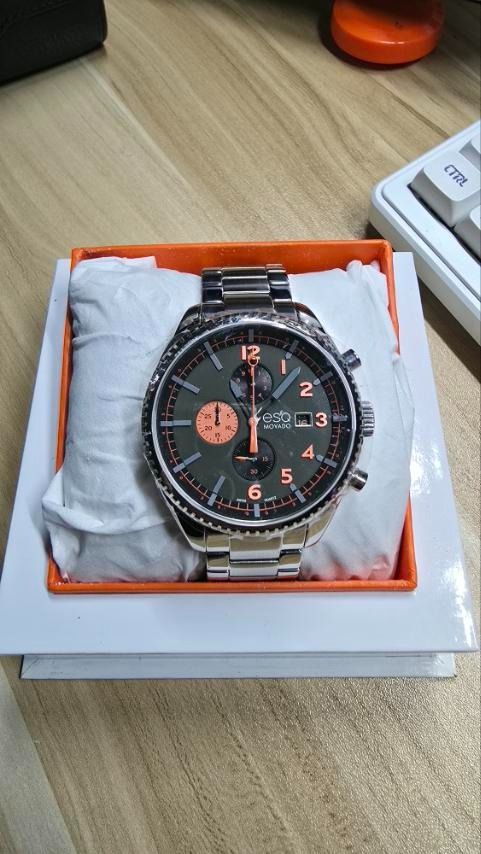 ESQ by Movado Chronograph men's (Category: Luxury Watches) located in Caloocan City. Submitted by dadasupena01715 (Listing ID 1415724802, Image 1). Description: Brand: ESQ by Movado (ESQ is an entry-level line from Movado). Collection: Catalyst. Model Number: 07301447. Movement: Swiss Quartz (battery-powered). Case Material: Stainless Steel. Case Diameter: 44.0mm. Dial Color: Olive Green with orange accents on the hands and markers. Functions: Ch