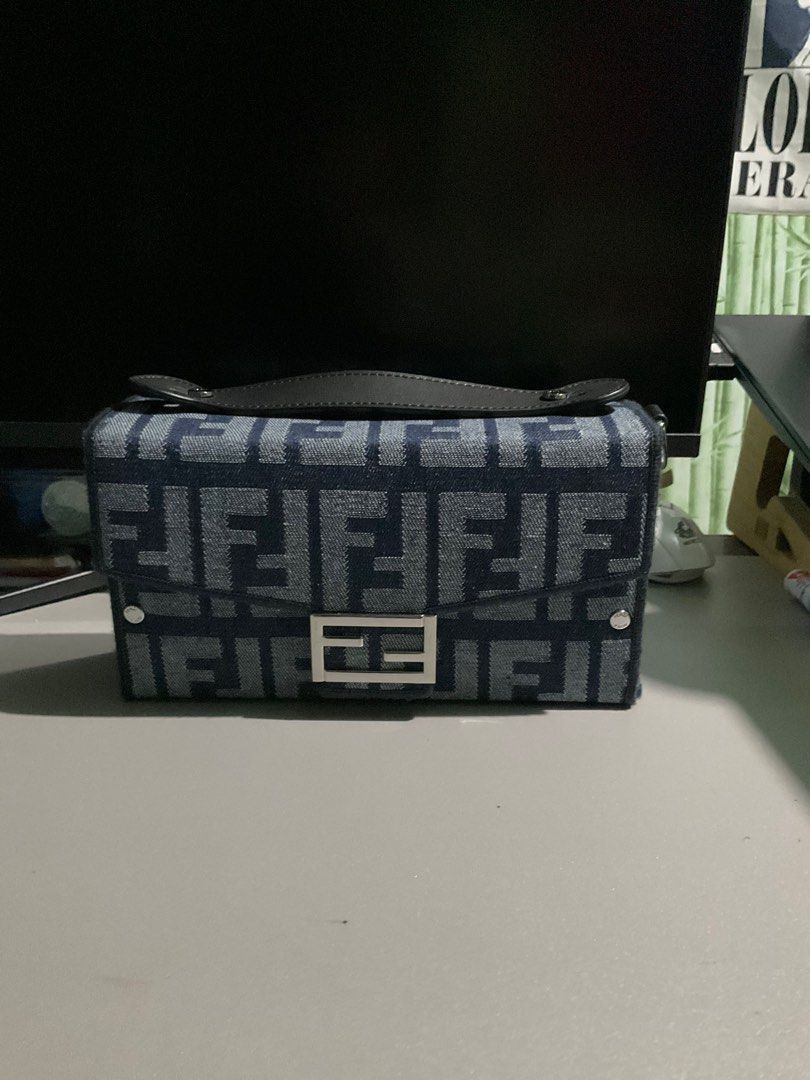 Fendi Denim Jacquard Soft Trunk Baguette Bag (Category: Luxury Bags & Wallets) located in Cabuyao City. Submitted by gerlieluxurycloset2024 (Listing ID 1415740554, Image 1). Description: Brand: Fendi Color: Blue Material: Denim and Microfiber Fabric Condition: light used with visible scratches sa hardware Coded: ✅✅ Inclusions: dust bag,paper works only. Price is still negotiable please dm me for your offer.