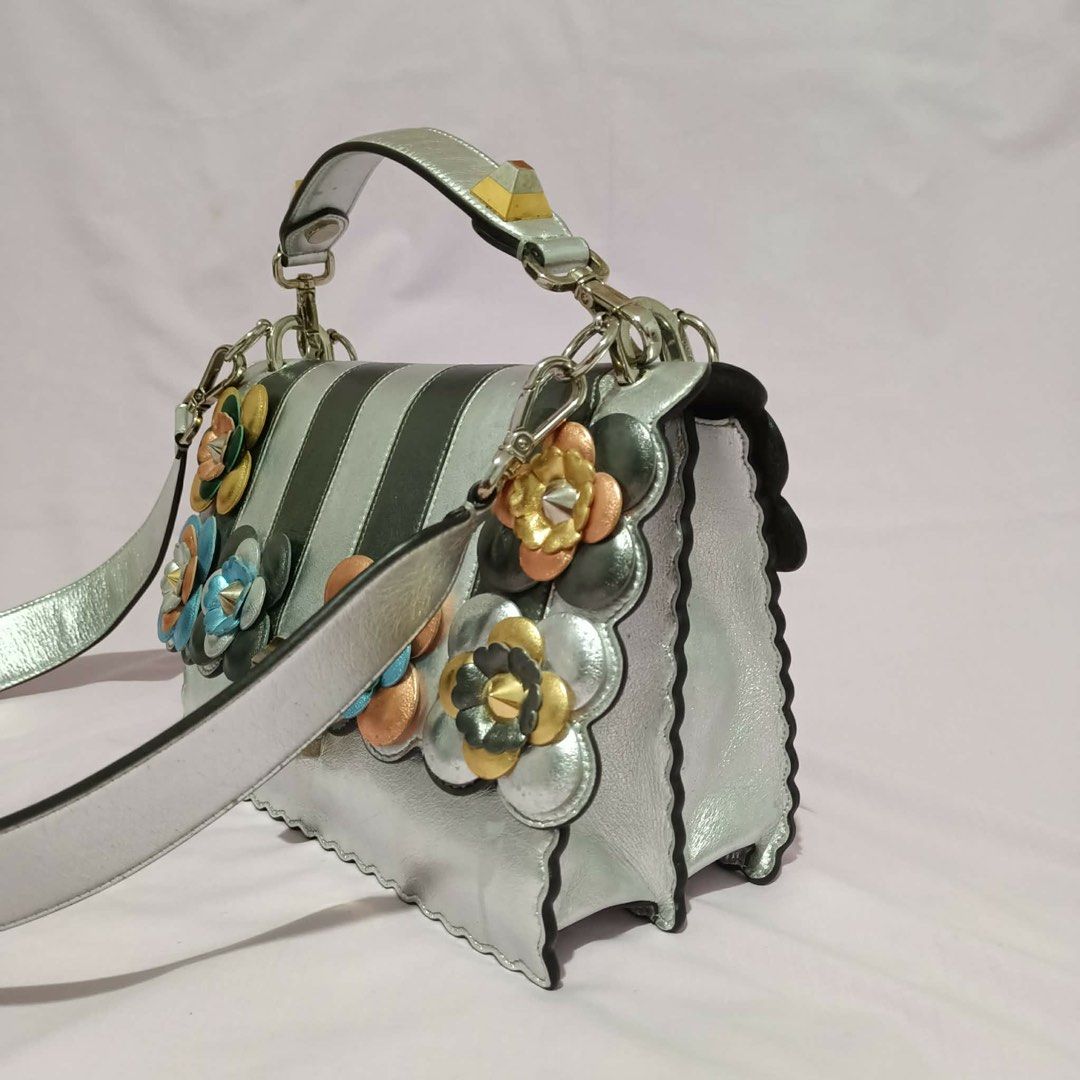 Fendi Silver Floral Embellished Handbag (Category: Luxury Bags & Wallets) located in Manila. Submitted by cooldolphin-c87b62 (Listing ID 1415759164, Image 2). Description: - Silver Fendi handbag - Floral embellishments - Top handle and detachable shoulder strap - Multiple interior compartments and small pocket - Scalloped edge design - Made in Italy.
