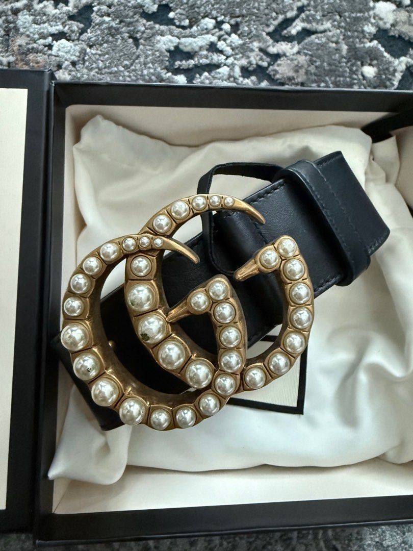 Authentic Gucci Pearl GG Belt (Category: Luxury Accessories) located in Manila. Submitted by annann1003 (Listing ID 1415776631, Image 1). Description: Authentic Gucci belt with pearl GG buckle. Black leather belt with gold-tone hardware. Includes original box and dust bag. Size 85-34. Made in Italy. The belt has several holes for adjustment. The buckle is adorned with pearls. The box has the Gucci logo..