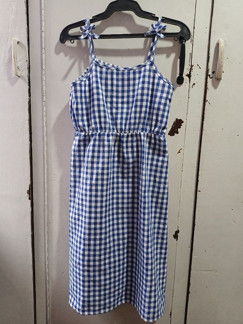 Kids Dress Preloved (Category: Babies & Kids Fashion) located in Cainta. Submitted by sjprelovedbotique (Listing ID 1415667942, Image 3). Description: White dress with a vibrant floral print featuring orange and blue flowers and leaves. It has short sleeves and a tie detail at the neckline. The dress has a slightly curved hemline..