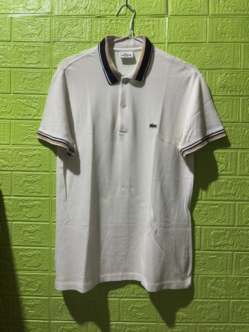 Lacoste Slim Fit Polo Shirt (Category: Tshirts & Polo Shirts ) located in Manila. Submitted by skydave196 (Listing ID 1415800449, Image 1). Description: - Lacoste polo shirt - Slim fit - Color: White - Collar with navy and tan stripes - Striped cuffs (navy and tan) - Short sleeves - Lacoste logo on chest - Size 5 -dimes 20/28.