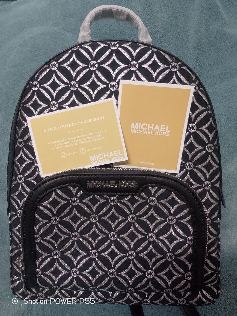 Michael Kors Jaycee MD Zip Pkt Backpack (Category: Backpacks) located in Binan City. Submitted by stuffshop29 (Listing ID 1415674532, Image 2). Description: Bought in Italy Authentic Michael Kors Jaycee backpack. Features a black and silver geometric pattern. Includes a front zip pocket and adjustable straps. The interior is lined with the Michael Kors logo. Comes with tags and care instructions. The hardware is silver-toned. Model number is 35F4