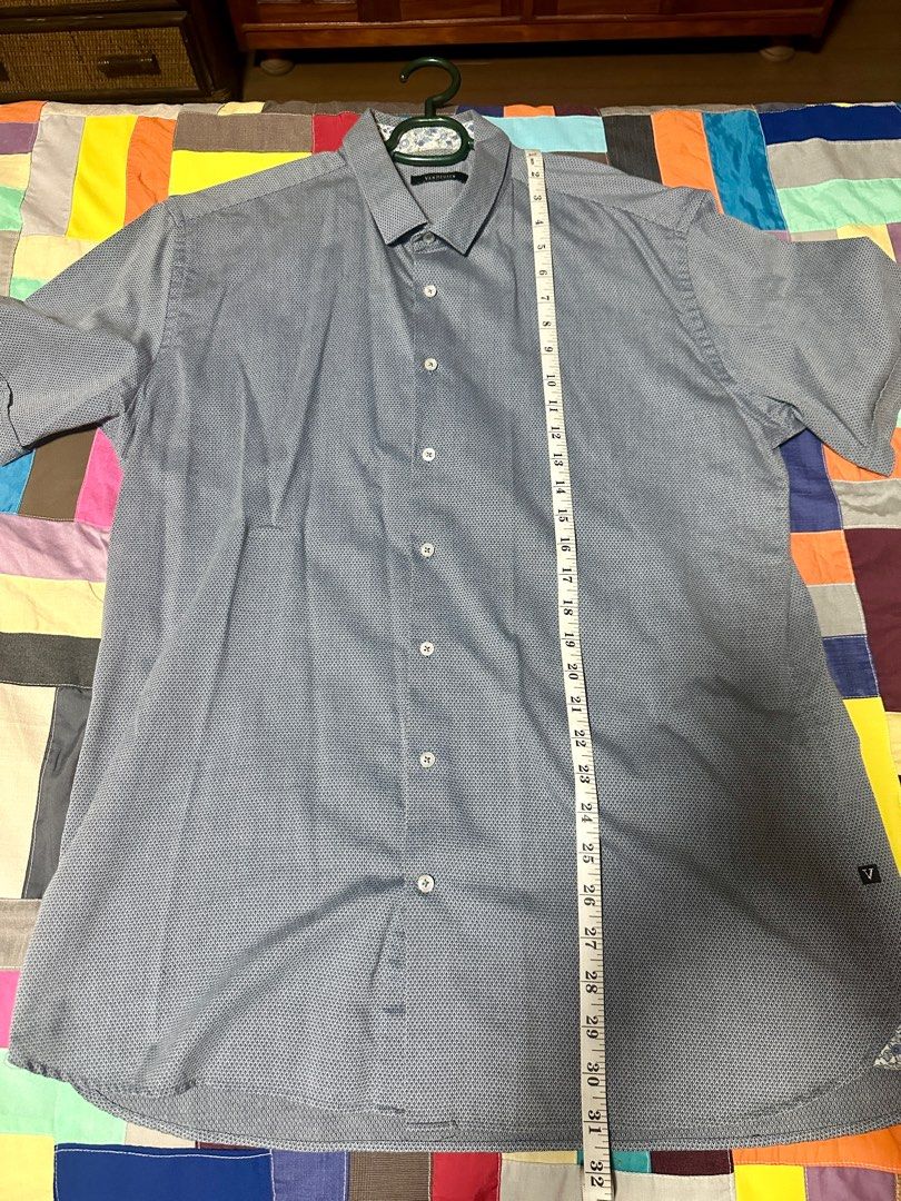 Van Heusen Short Sleeve Shirt (Category: Tshirts & Polo Shirts ) located in Quezon City. Submitted by declutter_incorporated (Listing ID 1415792424, Image 2). Description: - Van Heusen short sleeve shirt - Subtle textured pattern - Polycotton blend - Button-down front - Classic collar - Small logo on left side - Made in Thailand - Care: Machine wash cold, gentle cycle; non-chlorine bleach (if needed); do not tumble dry; cool iron.
