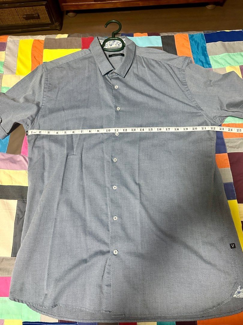 Van Heusen Short Sleeve Shirt (Category: Tshirts & Polo Shirts ) located in Quezon City. Submitted by declutter_incorporated (Listing ID 1415792424, Image 3). Description: - Van Heusen short sleeve shirt - Subtle textured pattern - Polycotton blend - Button-down front - Classic collar - Small logo on left side - Made in Thailand - Care: Machine wash cold, gentle cycle; non-chlorine bleach (if needed); do not tumble dry; cool iron.