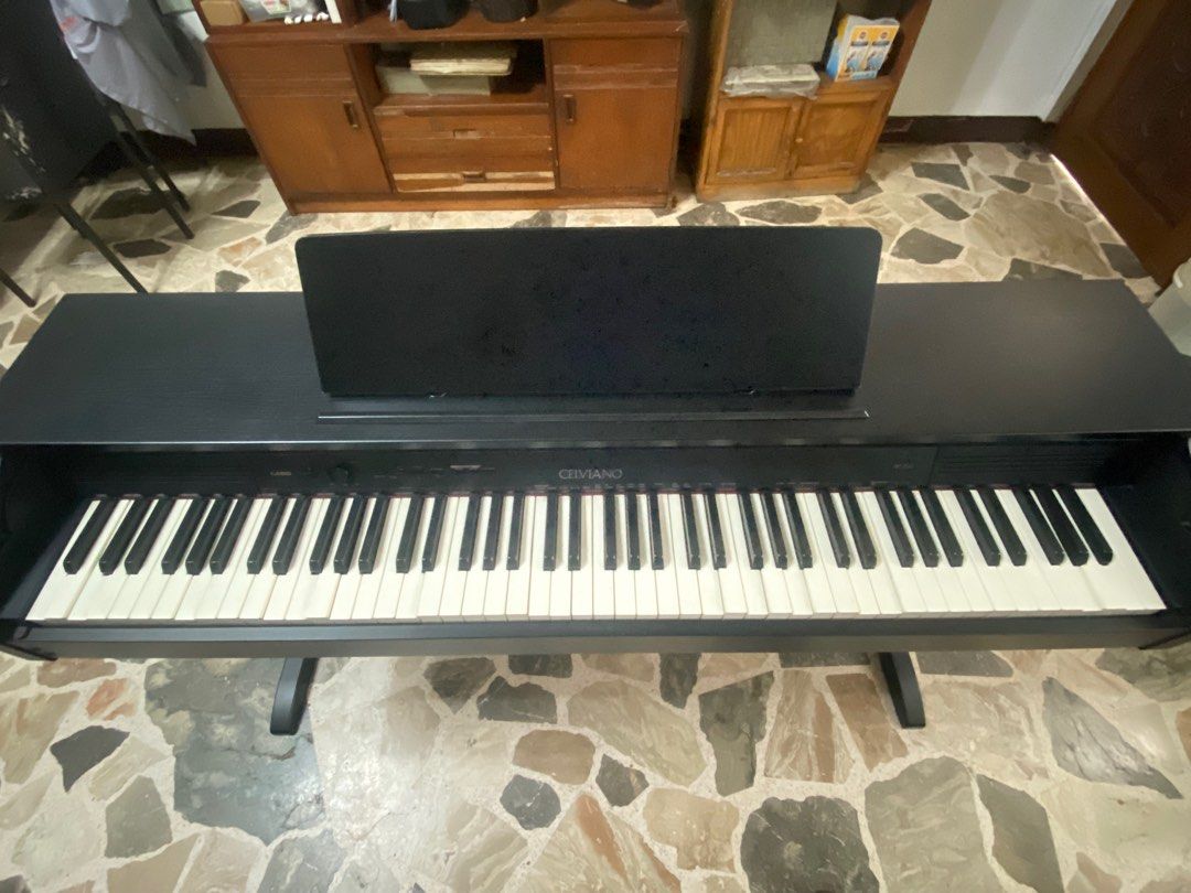 Casio Celviano AP-250 Digital Piano (Category: Musical Instruments) located in Quezon City. Submitted by chazzwazzer (Listing ID 1415844284, Image 2). Description: NEGOTIABLE PICKUP ONLY - Casio Celviano digital piano - Includes bench and music stand - Full keyboard with white and black keys - Black finish - Casio Celviano logo visible -Fully Weighted keys HONEST ISSUES -Has sunken keys -Doesn’t power on anymore.