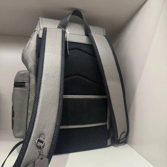 Coach Patchwork Backpack (Category: Luxury Bags & Wallets) located in Manila. Submitted by santosrich_419 (Listing ID 1415872672, Image 2). Description: - Stylish grey Coach backpack - Features multiple patches - Drawstring closure with buckle straps - Multiple pockets for storage - Coach logo pattern - Padded back for comfort - Top handle - Adjustable shoulder straps - Mix of textures and embellishments.