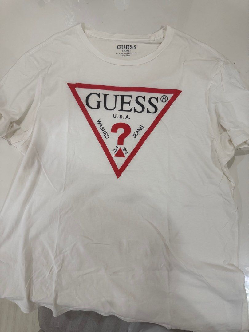 Guess T-shirt XL (Category: Tshirts & Polo Shirts ) located in Cabuyao City. Submitted by allorigz (Listing ID 1415868370, Image 1). Description: - Guess T-shirt - Features iconic red triangle logo - Includes "Guess" logo and "U.S.A. Jeans" text - Size: XL - Made in India - Classic crew neck design.