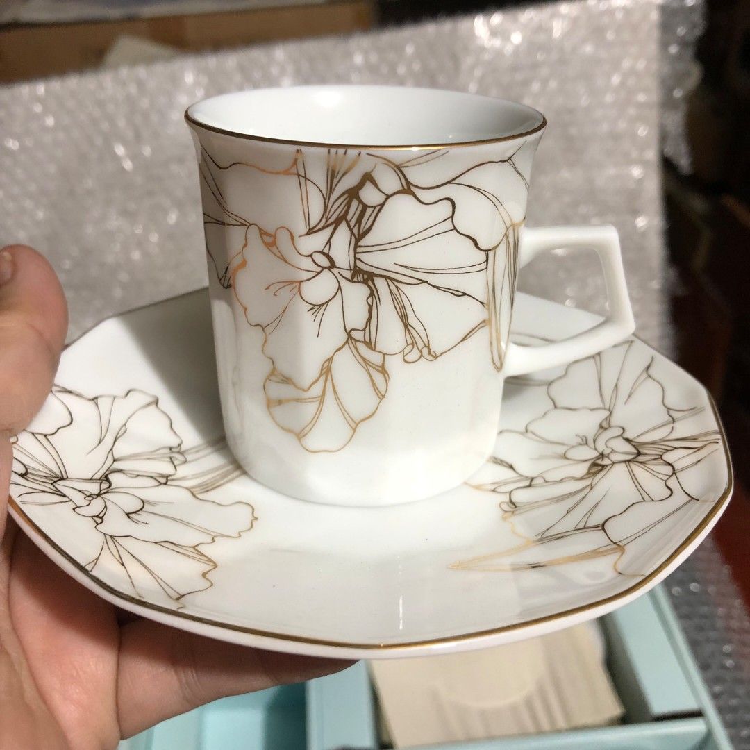 Maple White China Cup and Saucer Set (Category: Coffee & Tea Tableware) located in Caloocan City. Submitted by e_o62059 (Listing ID 1416001214, Image 2). Description: japan branded brand new;pristine condition;unused Elegant cup and saucer set from Maple White China. The set includes 5 cups and saucers, each adorned with a delicate floral design in gold. The cups have a unique geometric shape and the saucers have a matching design. Cup dimensions