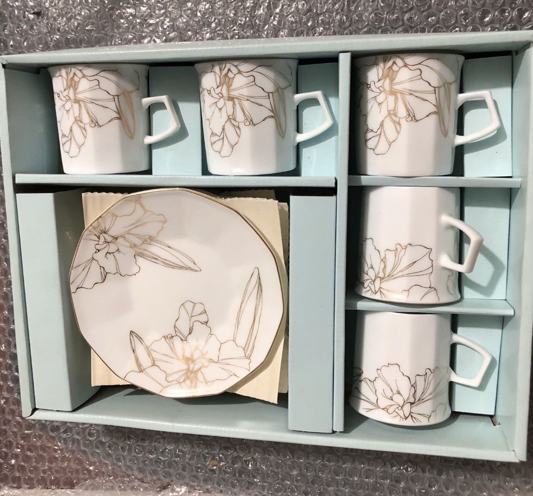Maple White China Cup and Saucer Set (Category: Coffee & Tea Tableware) located in Caloocan City. Submitted by e_o62059 (Listing ID 1416001214, Image 1). Description: japan branded brand new;pristine condition;unused Elegant cup and saucer set from Maple White China. The set includes 5 cups and saucers, each adorned with a delicate floral design in gold. The cups have a unique geometric shape and the saucers have a matching design. Cup dimensions