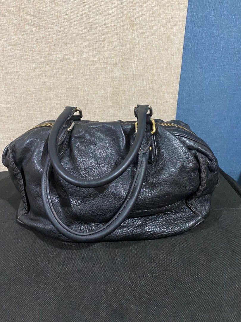 MCM Black Leather Handbag (Category: Luxury Bags & Wallets) located in Cagayan de Oro. Submitted by ericlarkyl89146 (Listing ID 1415881762, Image 3). Description: Black leather handbag by MCM. Features a top zipper closure, dual top handles, and lightly fade gold-tone hardware. The interior is lined with black fabric and includes a zippered pocket. The bag has a rounded shape with braided details on the sides. MCM logo is visible on the front and
