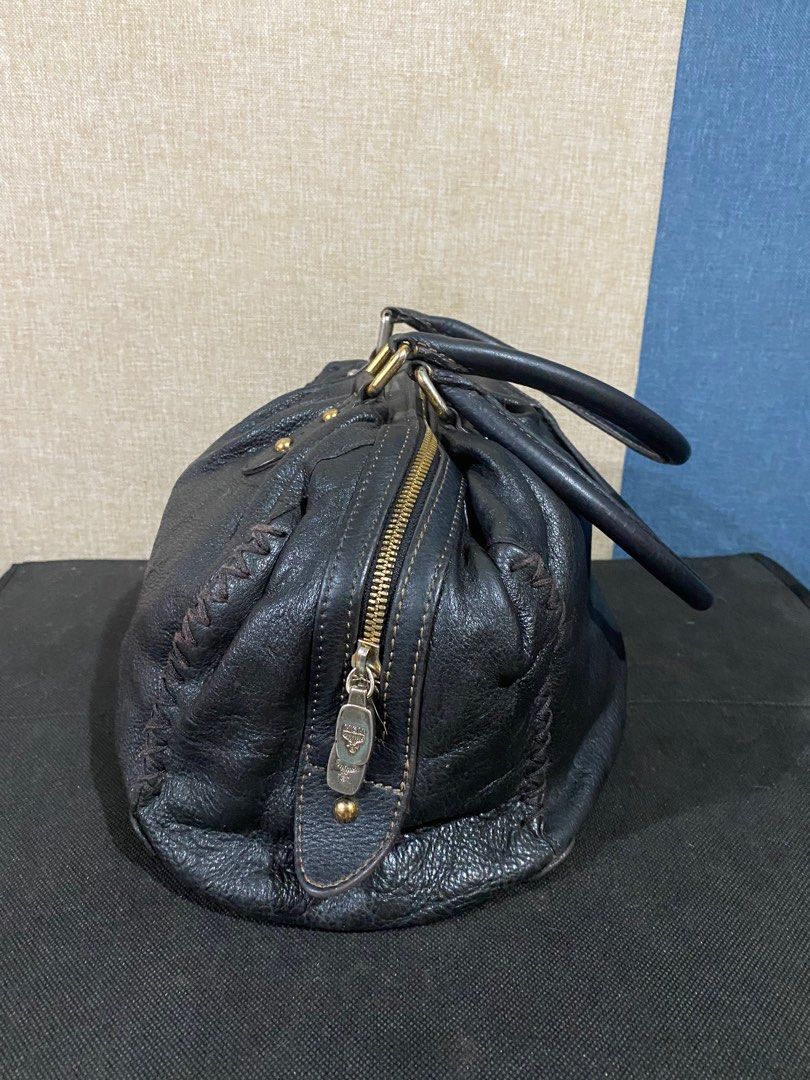 MCM Black Leather Handbag (Category: Luxury Bags & Wallets) located in Cagayan de Oro. Submitted by ericlarkyl89146 (Listing ID 1415881762, Image 2). Description: Black leather handbag by MCM. Features a top zipper closure, dual top handles, and lightly fade gold-tone hardware. The interior is lined with black fabric and includes a zippered pocket. The bag has a rounded shape with braided details on the sides. MCM logo is visible on the front and