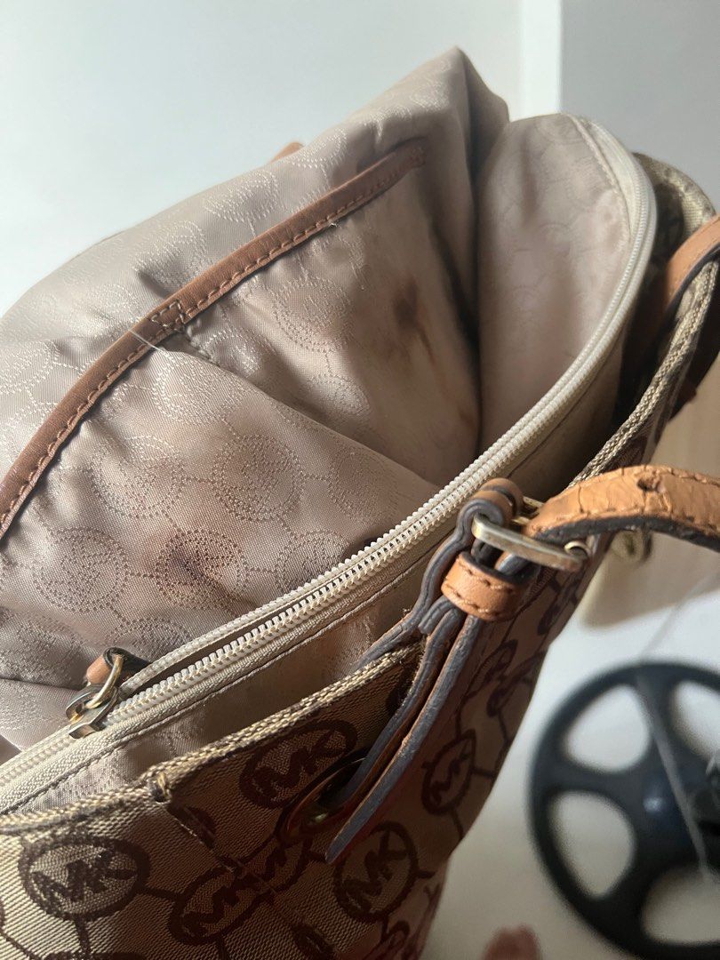 Michael Kors Jet Set Tote Bag (Category: Luxury Bags & Wallets) located in Quezon City. Submitted by sca1226 (Listing ID 1415915644, Image 3). Description: - Michael Kors tote bag - Brown leather straps - Monogram pattern - Two side pockets - Zipper closure main compartment - Interior small pocket - Signs of wear inside (with visible stain) - Last price posted.