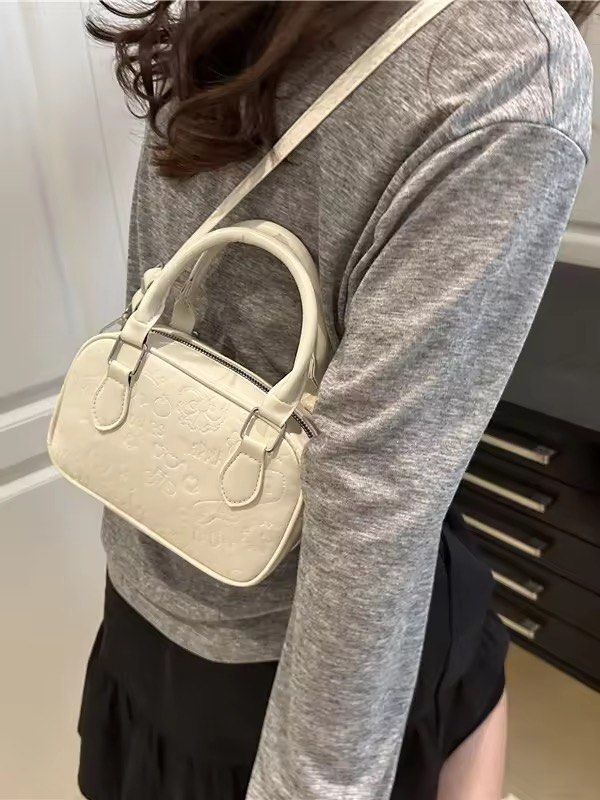 White Embossed Mini Boston Bag with Sling (Category: Luxury Bags & Wallets) located in Orani. Submitted by dejaniuph (Listing ID 1415975160, Image 3). Description: - Stylish white handbag - Embossed pattern - Top handle and detachable shoulder strap - Secure zipper closure - Good capacity for essentials - Perfect for everyday use.