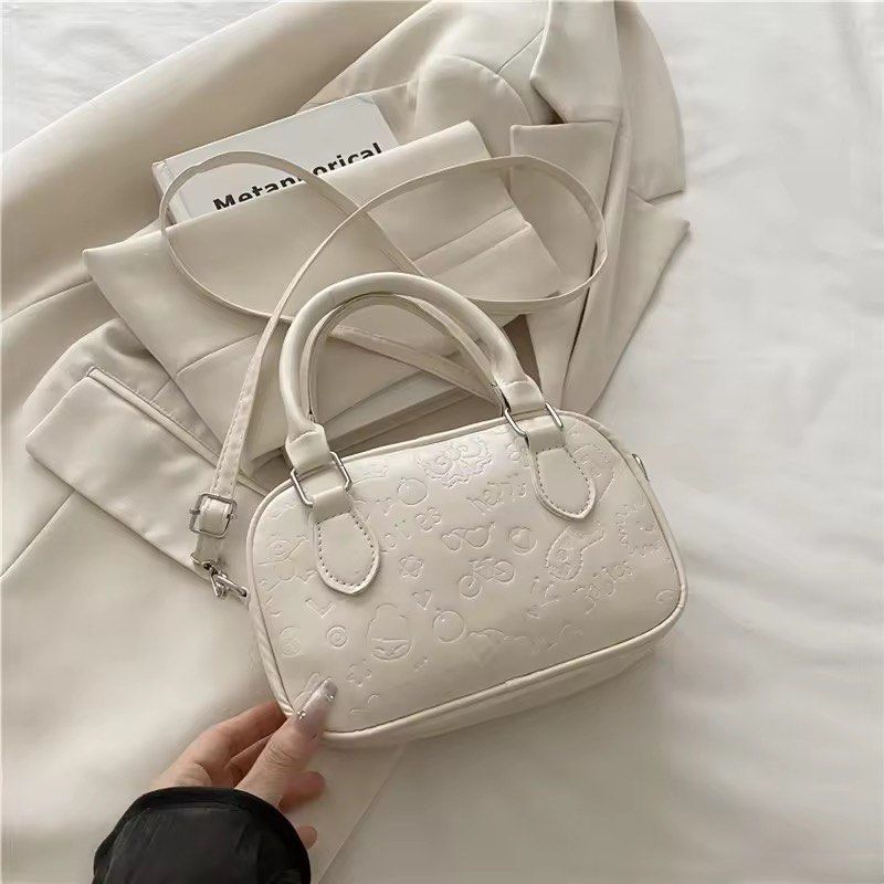 White Embossed Mini Boston Bag with Sling (Category: Luxury Bags & Wallets) located in Orani. Submitted by dejaniuph (Listing ID 1415975160, Image 1). Description: - Stylish white handbag - Embossed pattern - Top handle and detachable shoulder strap - Secure zipper closure - Good capacity for essentials - Perfect for everyday use.