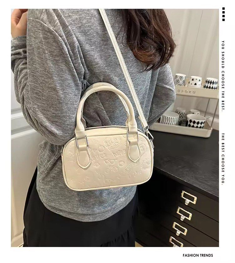 White Embossed Mini Boston Bag with Sling (Category: Luxury Bags & Wallets) located in Orani. Submitted by dejaniuph (Listing ID 1415975160, Image 2). Description: - Stylish white handbag - Embossed pattern - Top handle and detachable shoulder strap - Secure zipper closure - Good capacity for essentials - Perfect for everyday use.