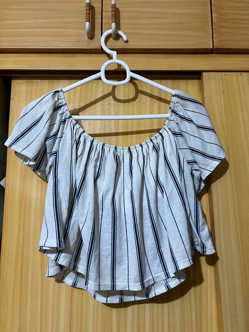 Bershka Off-Shoulder Striped Top (Category: Blouses) located in Mandaluyong City. Submitted by declutter.rs (Listing ID 1416105373, Image 1). Description: - Bershka off-shoulder top - Size: M - Color: White base with navy blue stripes - Condition: Minor yellow stains .