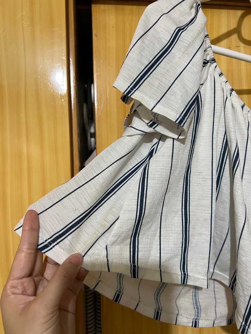 Bershka Off-Shoulder Striped Top (Category: Blouses) located in Mandaluyong City. Submitted by declutter.rs (Listing ID 1416105373, Image 3). Description: - Bershka off-shoulder top - Size: M - Color: White base with navy blue stripes - Condition: Minor yellow stains .