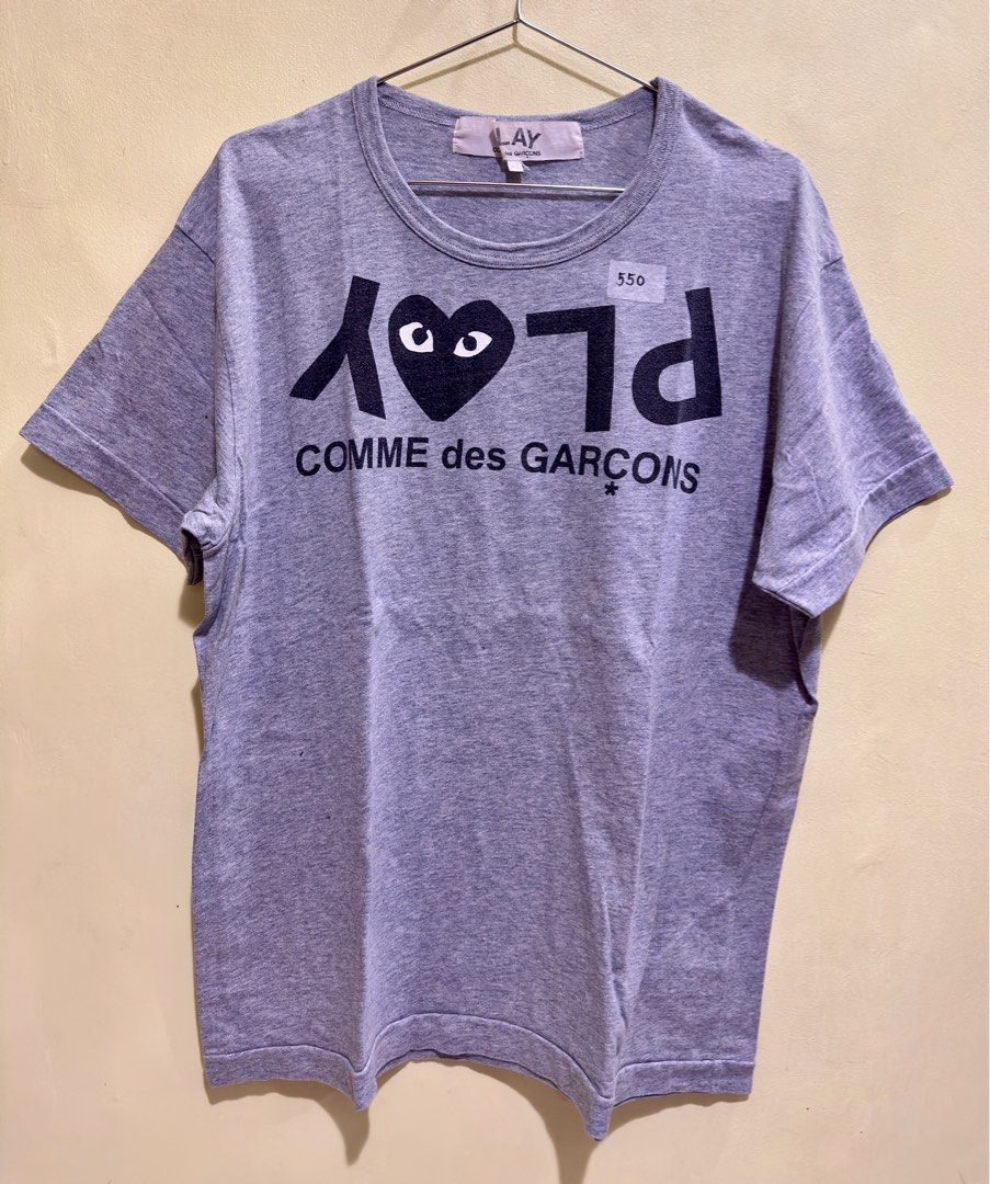 Comme des Garcons Play T-shirt (Category: Tshirts & Polo Shirts ) located in Manila. Submitted by lexa_199x (Listing ID 1416033310, Image 1). Description: - Gray Comme des Garcons Play T-shirt - Features the iconic heart logo with eyes - Brand name printed on the front - Crew neck - Short sleeves - Size XL.