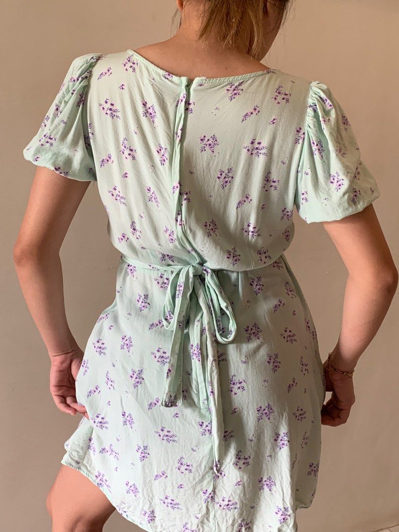 Floral Print Mini Dress (Category: Dresses) located in Cebu City. Submitted by declutter_ysh (Listing ID 1416116346, Image 2). Description: - Floral mini dress - V-neckline - Short, puffed sleeves - Purple and green floral print - Tie-back waist detail - Zipper closure - Lightweight fabric - Ideal for warm weather.