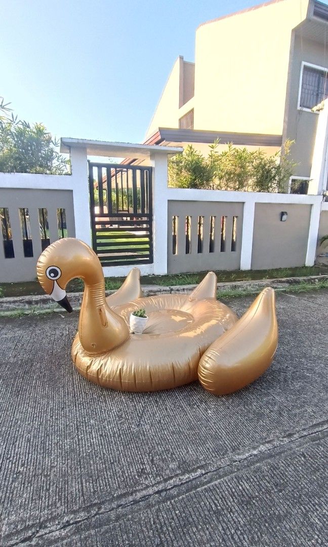Giant inflatable gold swan pool floater (Category: Water Sports) located in Dasmarinas. Submitted by solstice.style (Listing ID 1416159748, Image 2). Description: This is a giant inflatable gold swan pool float. It is designed for use in pools, beaches, or lakes. It is made of durable, eco-friendly PVC vinyl material RFS decluttering.