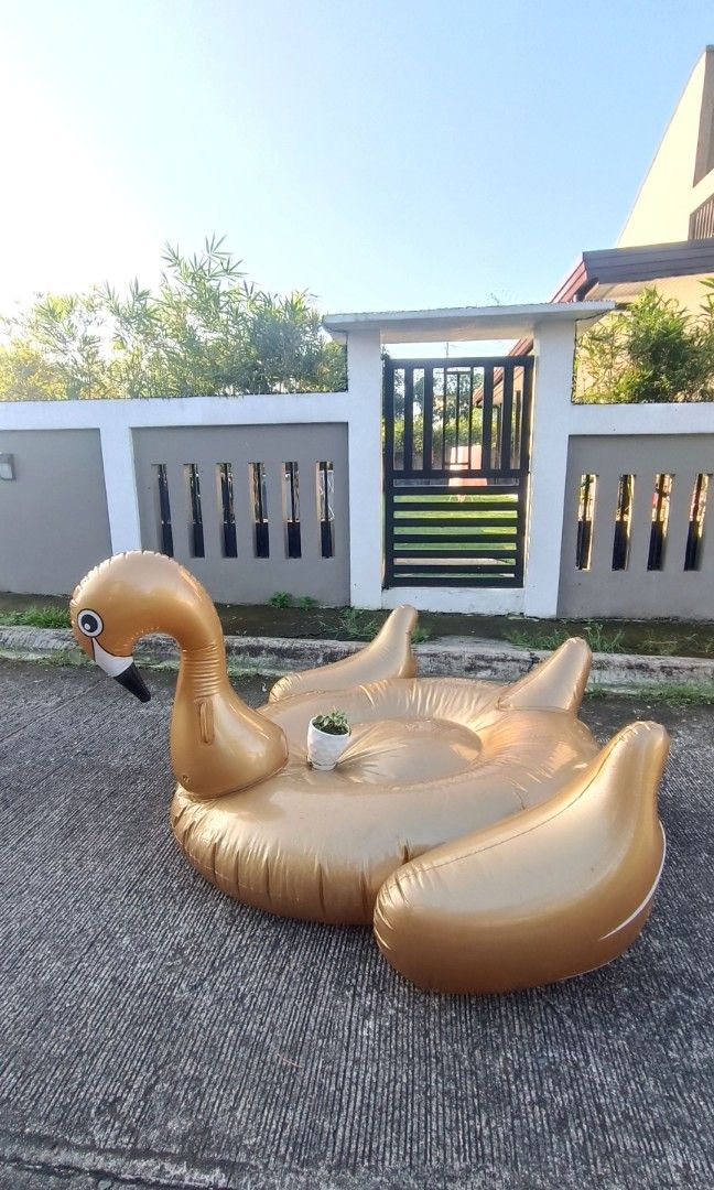 Giant inflatable gold swan pool floater (Category: Water Sports) located in Dasmarinas. Submitted by solstice.style (Listing ID 1416159748, Image 1). Description: This is a giant inflatable gold swan pool float. It is designed for use in pools, beaches, or lakes. It is made of durable, eco-friendly PVC vinyl material RFS decluttering.