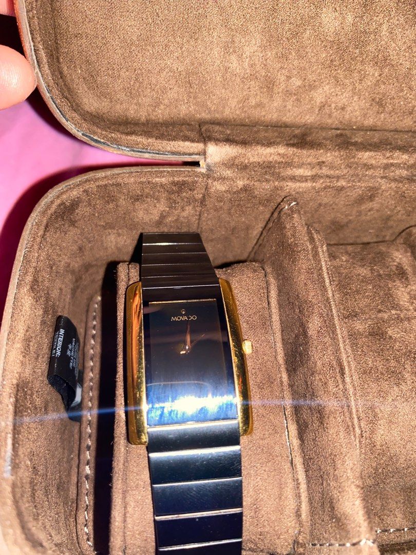 Movado Black Watch (Category: Luxury Watches) located in Manila. Submitted by vince1619 (Listing ID 1416111173, Image 3). Description: Elegant Movado watch with a black rectangular dial and a gold-toned bezel. The watch features a black link bracelet. The watch is presented on a red cloth with gold accents. It comes with a brown watch case. Original price is 46k peso..