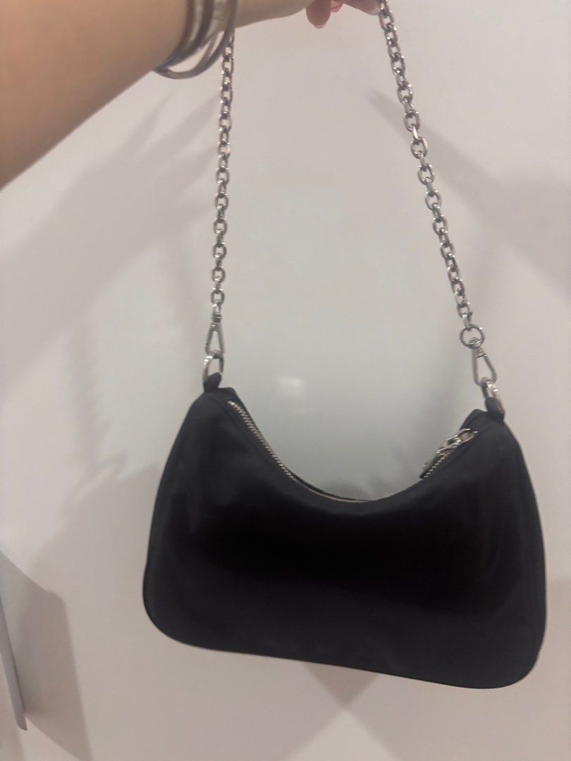Prada Chain Shoulder Bag (Category: Luxury Bags & Wallets) located in Cebu City. Submitted by makeupdontbreakup (Listing ID 1416128682, Image 2). Description: - Black Prada shoulder bag - Silver chain strap - Zippered closure - Small Prada logo - Curved shape - Silver-toned hardware - Nylon-like material Was given to me.