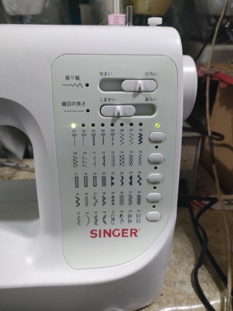 Singer Sewing Machine (Category: Craft Supplies & Tools) located in Manila. Submitted by faststone-c3c8 (Listing ID 1416211119, Image 2). Description: - White Singer sewing machine - Multiple stitch options - Adjustable stitch width and length - Includes a sample of sewn fabric - Suitable for various sewing projects - Singer logo visible.
