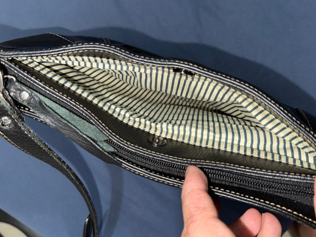Black Leather Shoulder Bag (Category: Shoulder Bags) located in Quezon City. Submitted by ramearc (Listing ID 1416362571, Image 3). Description: - Black pebbled leather shoulder bag - Back zippered pocket - Adjustable long strap - Silver-toned hardware - Striped fabric lining - Multiple compartments inside - White stitching details - Inner lining needs cleaning - w/ minimal scuffs and signs of use on the strap.