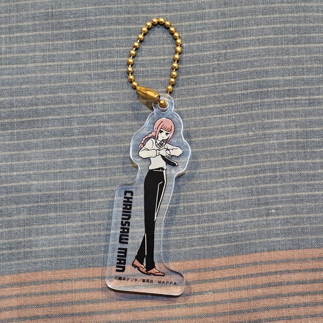 Chainsaw Man Makima Acrylic Keychain (Category: Character Goods) located in Quezon City. Submitted by chillsish (Listing ID 1416343169, Image 1). Description: - Chainsaw Man Makima acrylic keychain - Clear design - Gold-colored ball chain - Features the "Chainsaw Man" logo - Makima in a lying down pose - Japanese text on the back.
